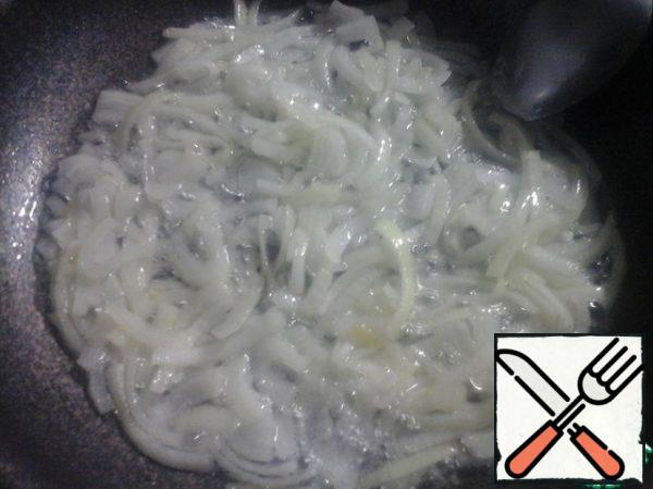 Peel the onion and cut it into half rings. Fry in vegetable oil until transparent.