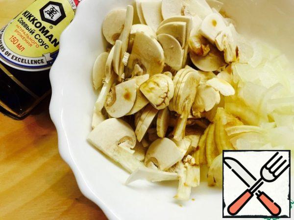 Mushrooms are washed, cut into plates, onions are cut into quarter rings.
Marinate them in a mixture of soy sauce and vinegar for 5 minutes.