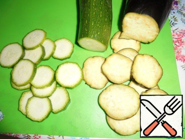 Cut the eggplant and zucchini into thin slices. Add salt to the eggplant and leave it for 5 minutes, then wash it and dry it with a paper towel. Cut the cherry tomatoes into halves.