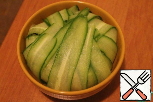 Put the salad in a bowl on the cucumber strips, turn the edges inside.
