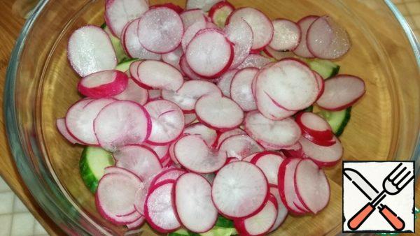 Cut off the tails of radishes, wash them and cut them into circles. We send it to a bowl with cucumbers.