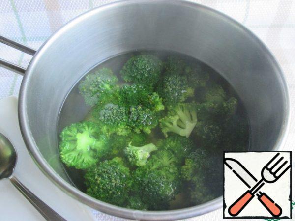 Divide the broccoli into inflorescences, boil in salted water for 3-4 minutes and toss in a colander.