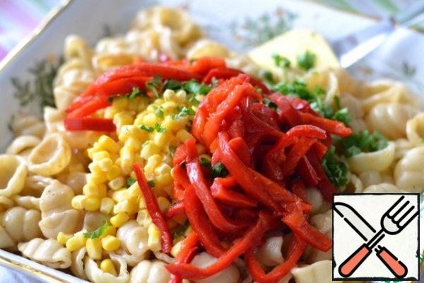 Finely chop the parsley and cut the bell pepper into strips.
Put the parsley, pepper and corn on the pasta.