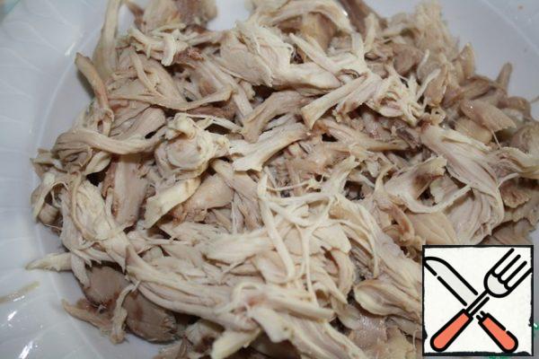Boil the chicken and disassemble the meat into fibers.
You can take the whole chicken or just the thighs or shins.