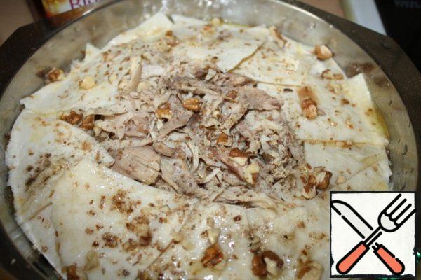 The last layer is spread only in a circle, in the center put a little more meat. Again, we grease with oil and sprinkle with nuts.
Put in preheated at 200 deg. oven.
Bake for about 20 minutes until Golden.