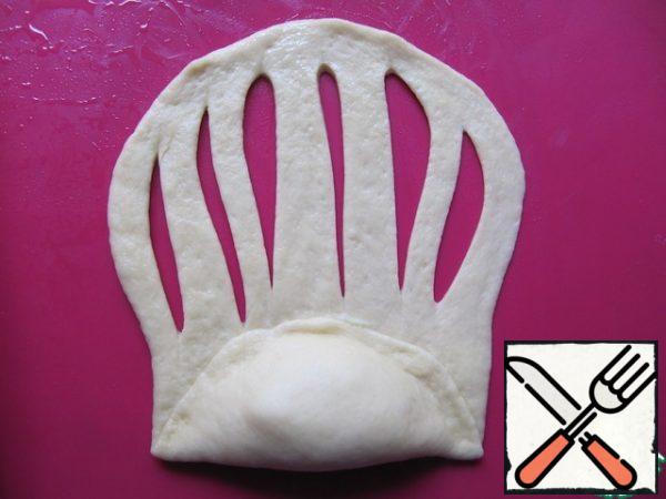 Wrap cream "dumpling", firmly press down the edges. Cut the remaining strip of dough into strips.