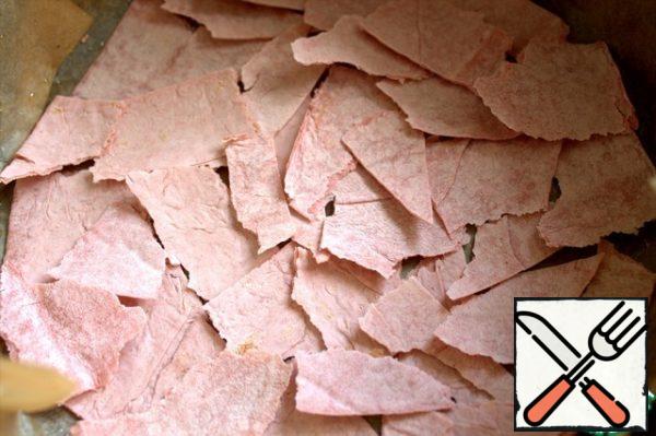 In a split form, lay oiled parchment and tear pieces of pita bread-this will be the basis of the pie.