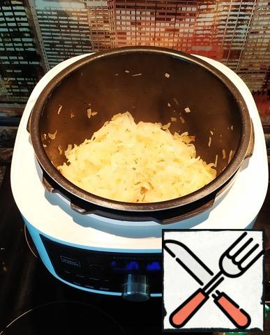 Next, pour 30 g of vegetable oil into the bowl of a pressure cooker. To put a program of "Frying/deep-Fried". Cut the onion and cabbage into rings. Fry in a slow cooker until Golden.