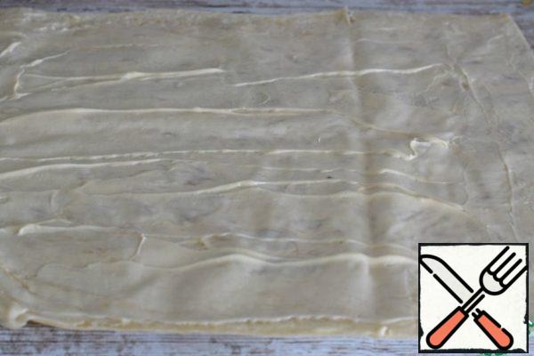 You need a thin yeast-free pita bread, about 100 g, size 30 * 40 cm. Spread the pita evenly with mayonnaise.