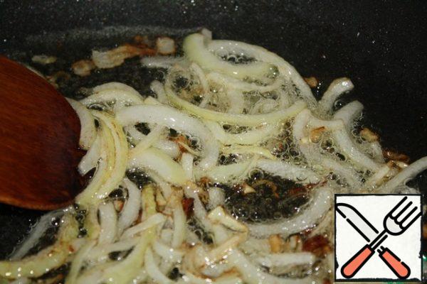 Cut the onion into half rings.
Heat the oil and fry the onion until Golden, sprinkling it with a pinch of sugar.