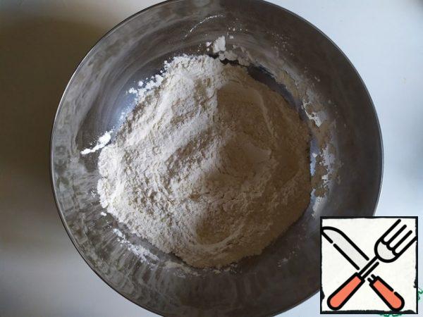 Mix the flour with salt. Add olive oil, yeast mixture, 240 ml of water. And knead the dough.