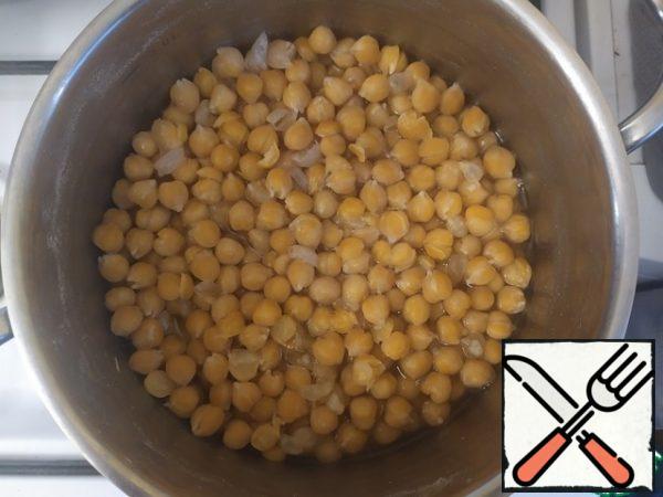 About this time, the chickpeas should arrive. We will pour the water into a separate container and store it. Cool the chickpeas to room temperature. Now, it is desirable to remove the skin from the chickpeas. This is a labor-intensive task, so not everyone is engaged in it. But it's better to do it. 