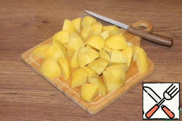The cooled potatoes are peeled from the skin and cut into large slices.