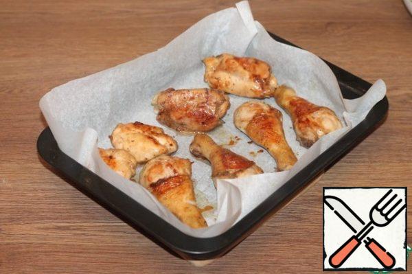 The baking dish is covered with baking paper and greased with oil (1 tbsp). Spread the chicken.