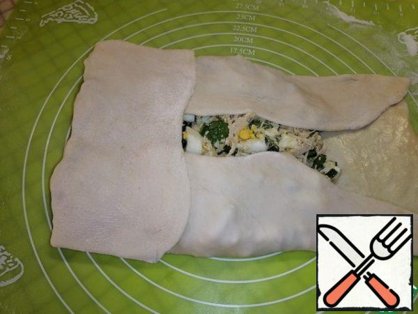 Wrap the edges to make a rectangle. And carefully roll out the top so that the filling is distributed inside.