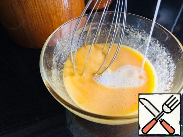 Heat the milk to 60 g. and add a thin stream to the yolk mass.