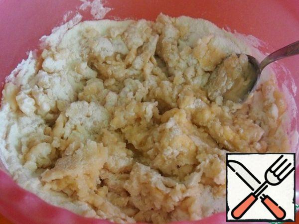 Add the odorless sunflower oil and chop the dough with a spoon, it turns out this lumpy mass.