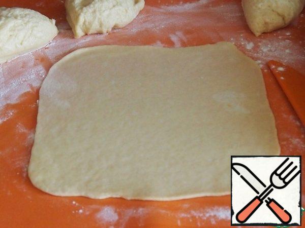 Roll out each piece of dough into a rectangle or square.