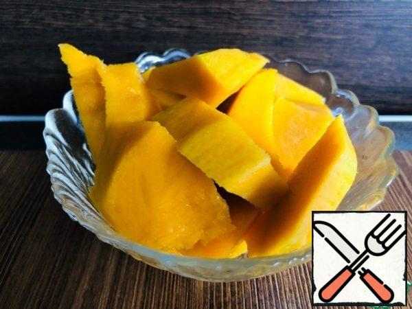 Peel the mango and cut it into pieces.