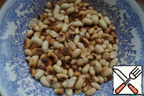 Fry the peanuts lightly in a pan, let them cool and peel.