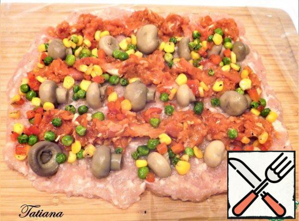 Cut the sheet from the baking sleeve longer than the shape by ~20 cm. cut along one side. Put the film on the table (cutting Board), lay out the light chicken mince, arrange the mushrooms and minced meat with paprika in rows on top, scatter it over (randomly)cold peas-corn-pepper.
Using a film, roll the meat layer into a roll, tie it with a fastener on one side (attached to the baking sleeves).