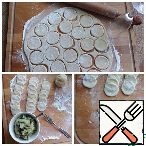 I always cut the dough for dumplings with a glass that fits my diameter or, as today, with a wine glass. Its diameter is 5.5 cm. That's enough for me. Here is son I have likes large dumplings and can be cut into dough diameter of on 1 centimeters more. From this amount of dough, I cut out 38 circles. Make the dumplings. We spread the filling in a circle, I form them in a simple and proven way and fasten the edges first with my fingers,and then with a fork with frequent teeth, after wetting the teeth with water. They are perfectly attached and do not fall apart when cooking. In this case, potatoes also help.