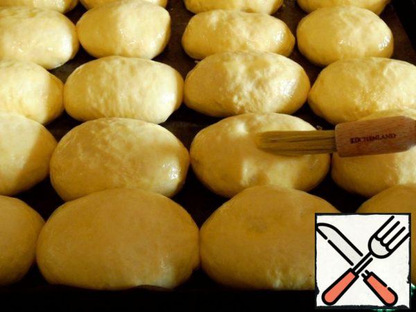 Place the rolls seam down on a baking sheet, which is greased with oil, or cover with a non-stick Mat. Cover with a towel or food wrap for further proofing.
After 30 minutes, well lubricate with a mixture of yolk and milk, now leave in the open state for 15 minutes.