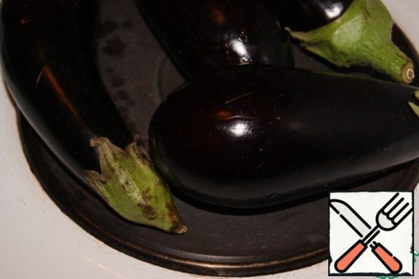 I'll make a reservation right away, the whole taste of this salad depends on how to bake vegetables. I really like to bake vegetables over an open fire.
If you have a gas stove, then put a divider on the burner, if as I have an electric one, then bake directly on the burner, if the hob is made of glass-ceramic, I don't even know what to advise... Well, if you don't like it with smoke, then bake it in the oven. Ideally, of course, bake on an electric grill.
Pierce the eggplants with a knife in several places and place them on a hot plate.