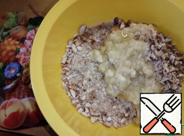 Mash the bananas with a fork and send them to the liver in a bowl. Add the chopped walnuts and pour in the melted butter. Mix everything well.