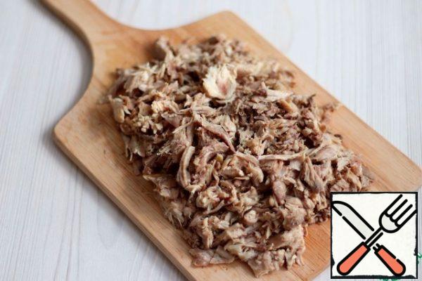 Then remove the meat from the bones and cut into small pieces.