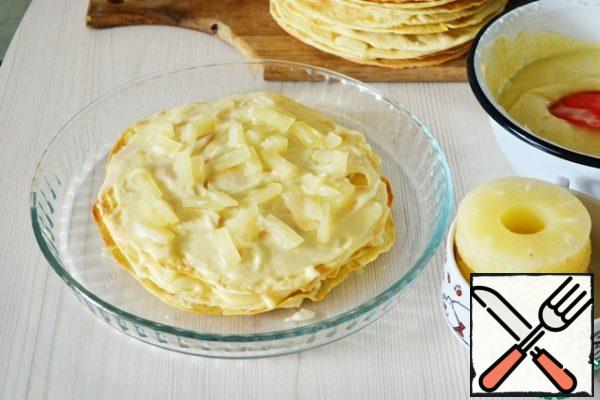 Assemble the cake: cover Each cake with cream and layer with pieces of canned pineapple. For each layer - 1 pineapple ring (cut into small pieces).