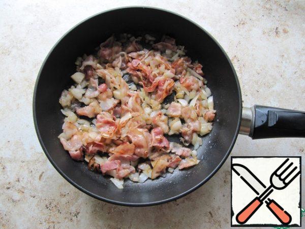 Cut the bacon into large pieces, fry it in a dry pan so that the fat is melted (do not dry it!), add the sliced onions, and strain everything until the onion is transparent.