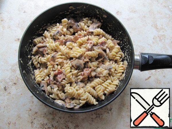 Combine the pasta, bacon and mushrooms in a pan, mix, pour the sauce, bring to a boil, and sprinkle with grated cheese before serving. Serve immediately!