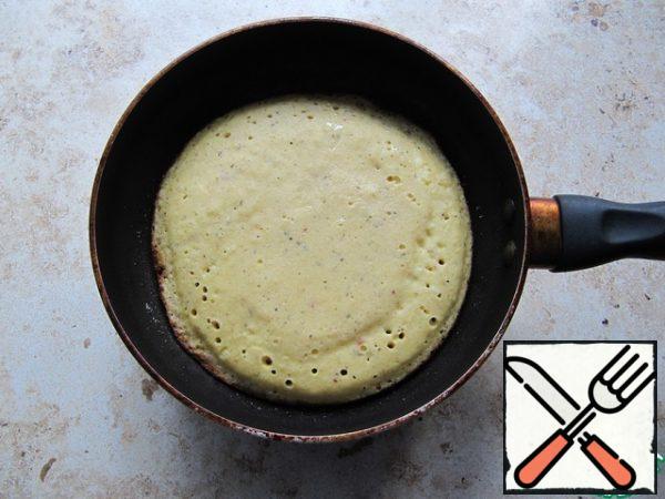 On a well-heated dry pan (diameter about 20 cm), pour the egg mixture-the basis for pizza, reduce the heat, cover with a lid. To bake without oil-you need a pan with a good coating, if in doubt-for baking a pancake, grease the pan with vegetable oil.
