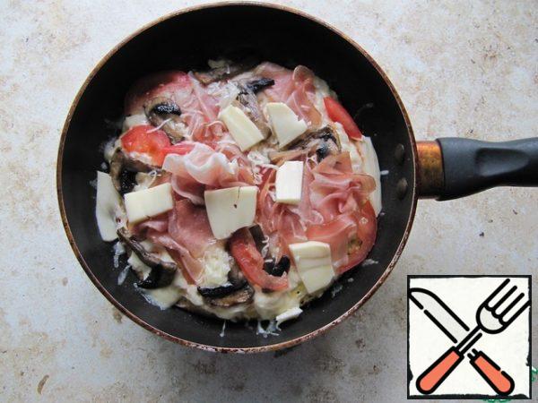 Put the grated cheese, ham, tomatoes in a piece, mushrooms. Bring to a boil under a lid on the stove or place under the grill until the cheese melts. Serve hot!