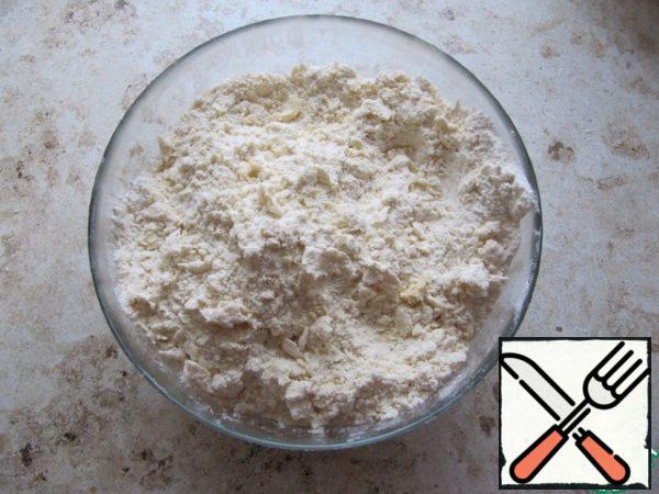 Flour sifted with starch, a pinch of salt, sugar, quickly and gently RUB with butter into a crumb. When preparing chopped dough using a combine, you need to punch all the ingredients with a metal knife into a fine oil crumb.