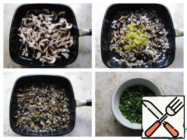 Chop the mushrooms coarsely, lightly fry them with onions in a pan heated with vegetable oil, add a pickled cucumber cut into small cubes, fry everything until ready, bring it to taste, adding salt and pepper. Finely chop the green onion feathers.