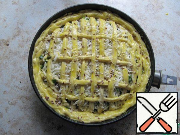 Top with a layer of grated cheese. From the remaining dough, form strips, cover the top of the pie with them, grease with yolk, and sprinkle with a mixture of seeds. Bake in a preheated oven to 180*C until ready (test for a dry ray).