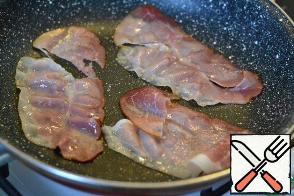 Finely chop the onion.
Quickly fry the bacon pieces in a dry pan.
Put the bacon on a plate.
