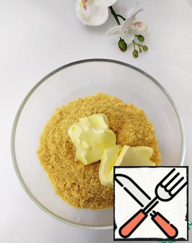 Put the softened butter in a bowl with sand crumbs. Mix the mass well.