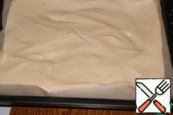 Form the size of 24x21 cm cover with baking paper. If you doubt its quality, smear with oil.
Place the light dough in the form and distribute it evenly.