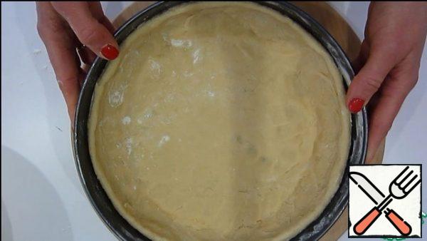 Add the remaining flour and knead the dough.
Spread in a form with a diameter of 26 cm and put in the refrigerator for 15-20 minutes.