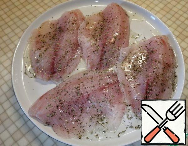 Season the fish fillets with salt and pepper, sprinkle with oregano and pour 2 tablespoons of olive oil. Leave for 15 minutes.