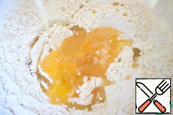 Sift the flour, make a hole, pour in the egg and oil mixed with salt.