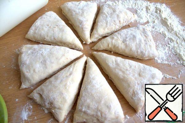 Transfer the remaining dough to the table with flour, slightly flatten into a flat cake, divide into segments.