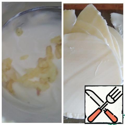 Squeeze the garlic into the sour cream, add the spices, mix, and cut the cheese into thin slices.