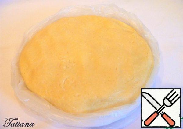 The dough should be soft, but dense (not viscous). Place the dough in a bag (shape it into a flatbread, it will be easier to distribute it in the form), put it in the refrigerator for 1 hour.