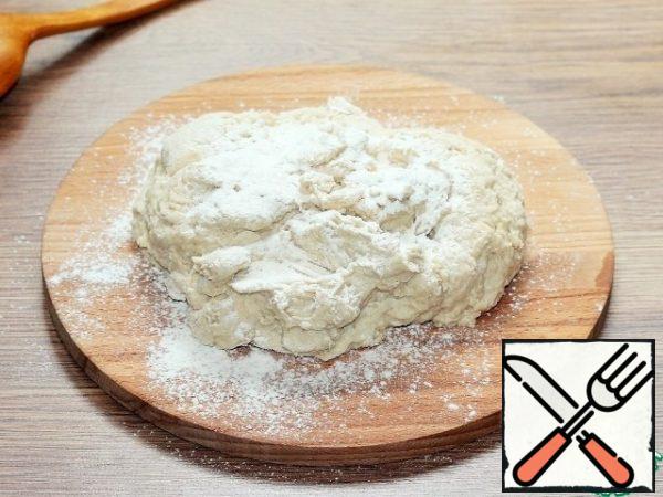 The last two spoons of flour are poured on a cutting Board and knead a smooth, shiny dough that does not stick to your hands.