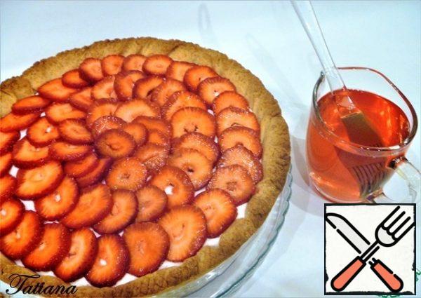 Prepare the strawberry jelly (according to the instructions on the package). After half an hour (possibly faster), the top of the yogurt cream froze. Spread the strawberry rings all over the surface. To prevent the strawberry from surfacing, apply the jelly in several passes. Apply the first two layers of jelly with a brush, allowing each layer to solidify. When the strawberries are firmly fixed, and will float, you can evenly pour out the remaining jelly.