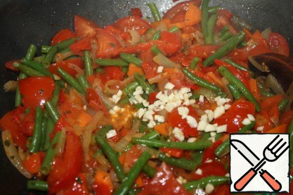 Cut tomatoes, peppers, hot peppers and garlic.
Add to the onions and carrots.
My beans are frozen, we add them to the same place.
With constant stirring, fry until the tomatoes soften.
Add oregano, Basil and parsley to taste.